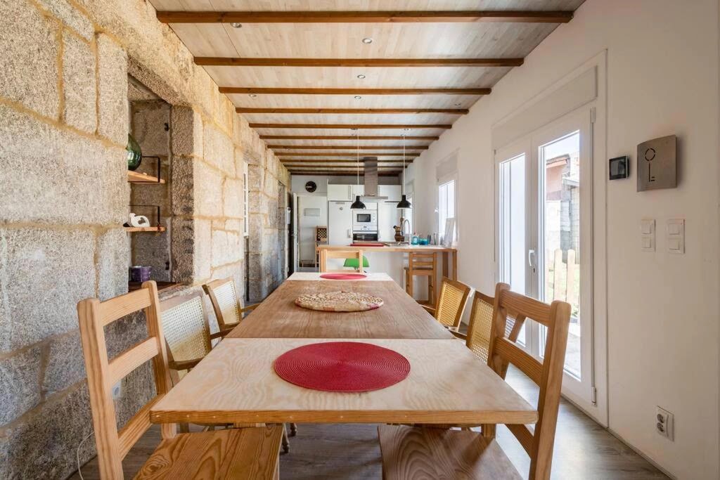 Casa Bubela Dozón - Salón comedor con vigas y pared de piedra