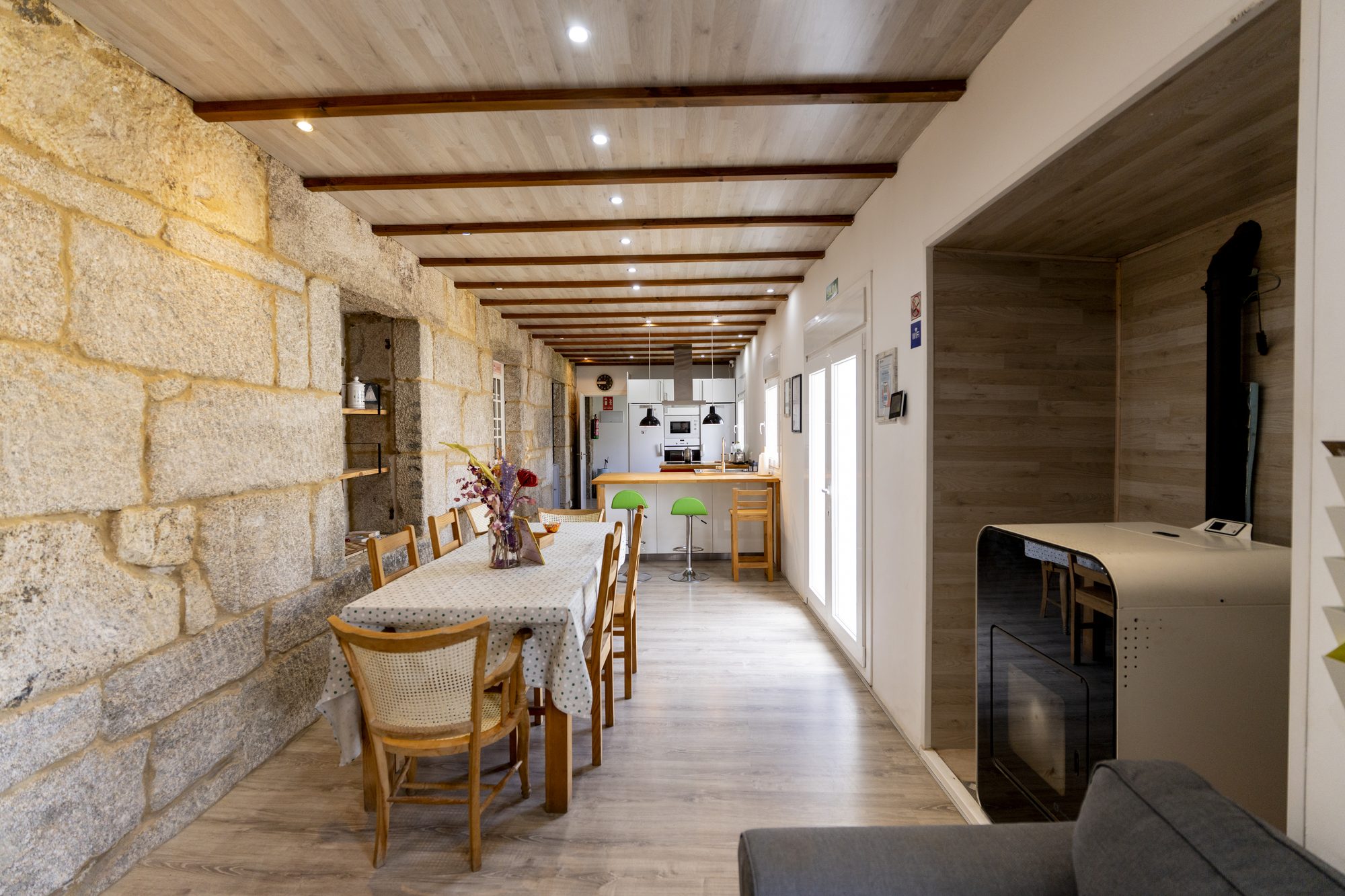 La Casa - Salón comedor de Casa Bubela Dozón con pared de piedra gallega