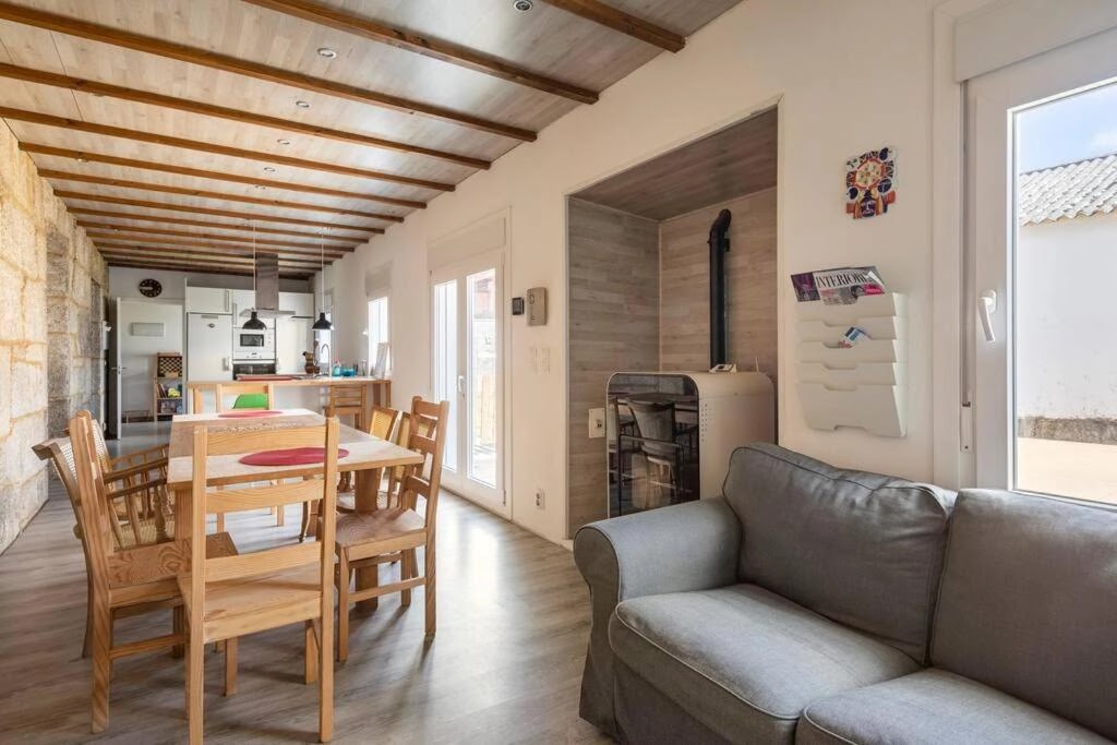 Salón con sofá y estufa de Casa Bubela Dozón, alojamiento rural en el Camino de Santiago